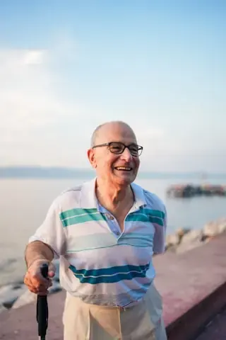 A smiling older man by the sea