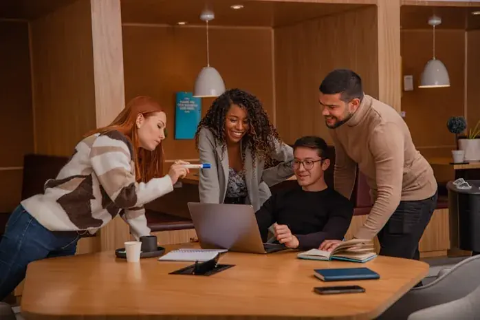 A team working together around a laptop