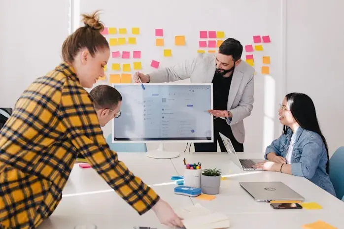 Colleagues planning at a whiteboard of sticky notes